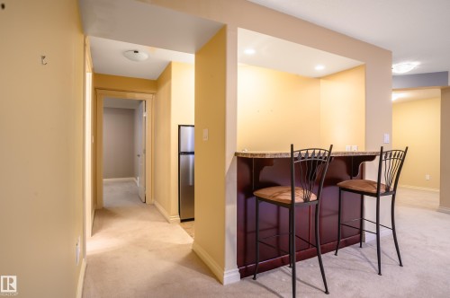 Indoor dry bar with light carpet, freestanding refrigerator, and recessed lighting - 48 Fairway Point(E), Spruce Grove, AB - Indoor Photo Showing Other Room