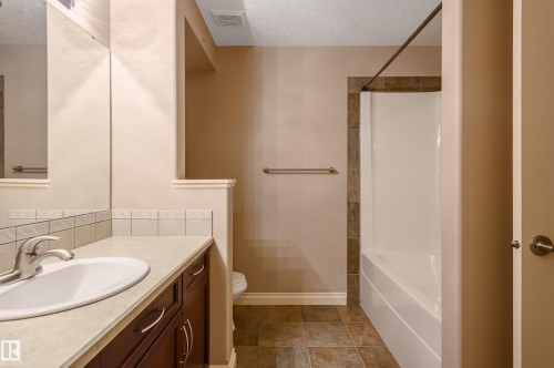 Full bath featuring a textured ceiling, vanity, and shower / bath combination - 48 Fairway Point(E), Spruce Grove, AB - Indoor Photo Showing Bathroom