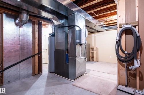 Unfinished below grade area featuring heating unit and water heater - 48 Fairway Point(E), Spruce Grove, AB - Indoor Photo Showing Basement