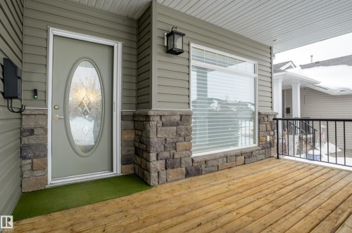 View of exterior entry with stone siding - 48 Fairway Point(E), Spruce Grove, AB - Outdoor With Deck Patio Veranda With Exterior