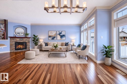 Living area featuring wood-type flooring, a fireplace, and crown molding this is a virtual photo showing you how it could look - 48 Fairway Point(E), Spruce Grove, AB - Indoor Photo Showing Living Room With Fireplace