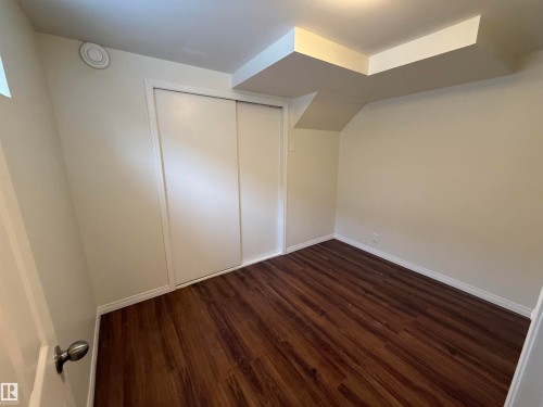 Featuring dark wood-style flooring and baseboards - 13323 68 Street, Edmonton, AB - Indoor Photo Showing Other Room