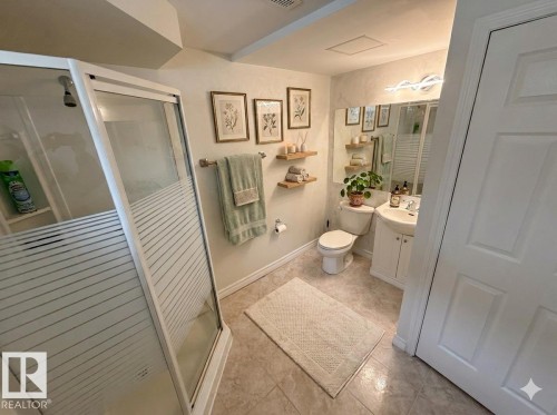 Virtually staged Bathroom with a stall shower, vanity, and light tile patterned floors - 13323 68 Street, Edmonton, AB - Indoor Photo Showing Bathroom