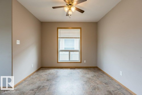 Spare room featuring stone finish floors and a ceiling fan - 4827 54 Avenue, Wetaskiwin, AB - Indoor Photo Showing Other Room