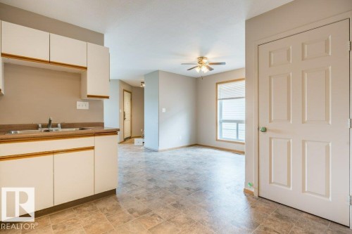 Kitchen featuring a ceiling fan, stone finish floors, and dual tone cabinetry - 4827 54 Avenue, Wetaskiwin, AB - Indoor Photo Showing Kitchen With Double Sink