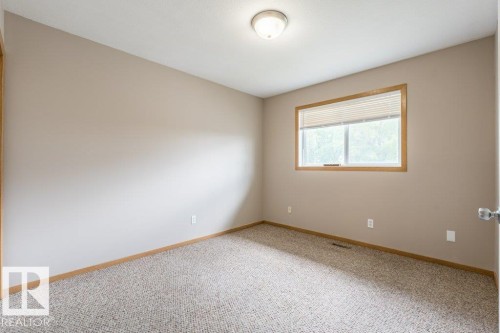 Spare room featuring baseboards and light colored carpet - 4827 54 Avenue, Wetaskiwin, AB - Indoor Photo Showing Other Room