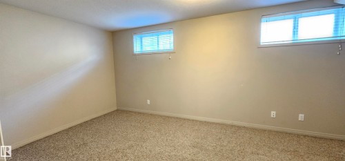 Unfurnished room featuring baseboards and light colored carpet - 4827 54 Avenue, Wetaskiwin, AB - Indoor Photo Showing Other Room