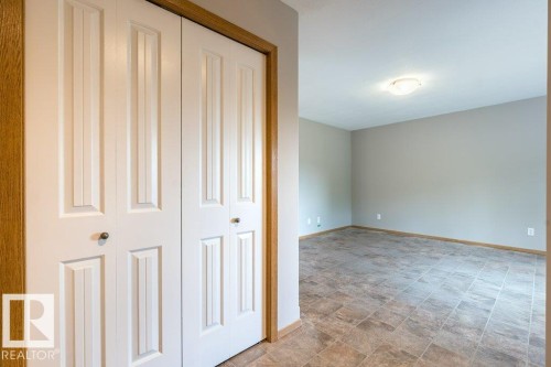 Unfurnished bedroom with stone finish floors and a closet - 4827 54 Avenue, Wetaskiwin, AB - Indoor Photo Showing Other Room