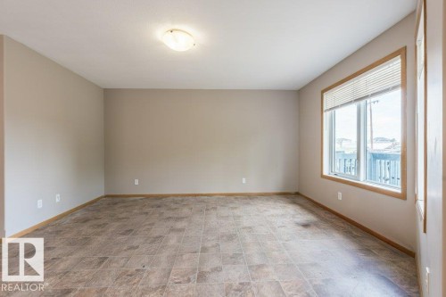 Spare room featuring baseboards and stone finish flooring - 4827 54 Avenue, Wetaskiwin, AB - Indoor Photo Showing Other Room
