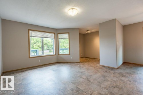Empty room with baseboards and stone finish flooring - 4827 54 Avenue, Wetaskiwin, AB - Indoor Photo Showing Other Room