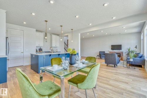 Dining room with light wood-style flooring, a textured ceiling, and recessed lighting - 8320 Mayday Link Sw, Edmonton, AB - Indoor