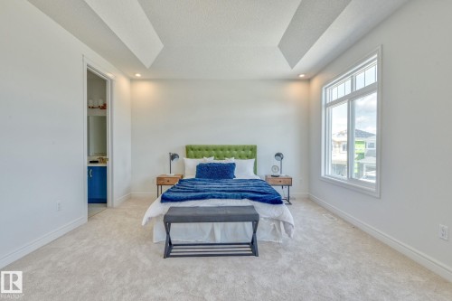 Bedroom featuring light carpet, recessed lighting, connected bathroom, and a textured ceiling - 8320 Mayday Link Sw, Edmonton, AB - Indoor Photo Showing Bedroom