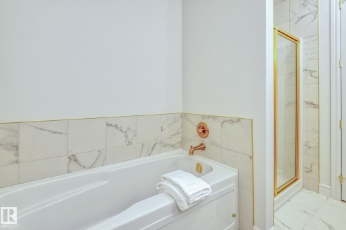 Bathroom featuring a marble finish shower and a bath - 8320 Mayday Link Sw, Edmonton, AB - Indoor Photo Showing Bathroom