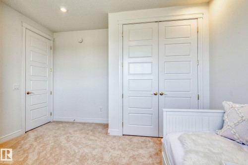 Bedroom with a closet, carpet flooring, and a textured ceiling - 8320 Mayday Link Sw, Edmonton, AB - Indoor Photo Showing Bedroom