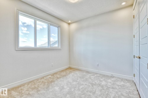 Unfurnished room with a textured ceiling, light colored carpet, and recessed lighting - 8320 Mayday Link Sw, Edmonton, AB - Indoor Photo Showing Other Room