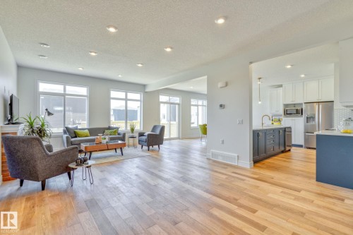 Living area with a textured ceiling, light wood-style floors, and recessed lighting - 8320 Mayday Link Sw, Edmonton, AB - Indoor