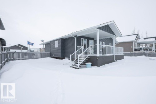 Snow covered rear of property featuring a wooden deck - 11116 103 Street, Westlock, AB - Outdoor
