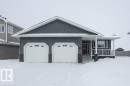 View of front of property featuring covered porch, stone siding, and an attached garage - 11116 103 Street, Westlock, AB  - Outdoor 