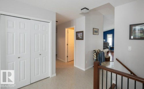 Hall featuring an upstairs landing, a textured ceiling, and light flooring - 11116 103 Street, Westlock, AB - Indoor Photo Showing Other Room
