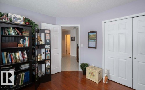 Living area featuring dark wood-type flooring and a textured ceiling - 11116 103 Street, Westlock, AB - Indoor
