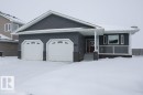 View of front facade with a garage, a porch, and stone siding - 11116 103 Street, Westlock, AB  - Outdoor 