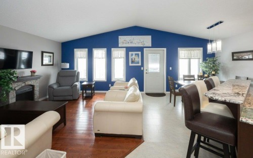 Living area with a fireplace and wood-type flooring - 11116 103 Street, Westlock, AB - Indoor