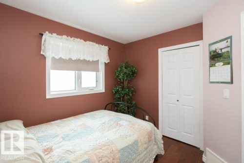 Bedroom with dark wood-style flooring, a closet, and a textured ceiling - 11116 103 Street, Westlock, AB - Indoor Photo Showing Bedroom