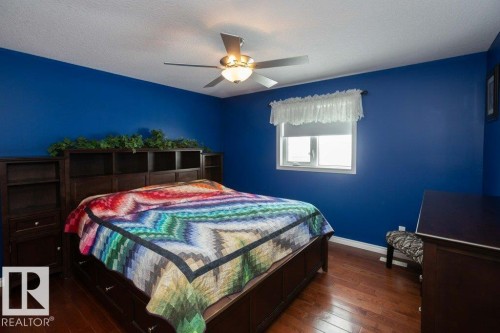 Bedroom featuring dark wood-style flooring, ceiling fan, and a textured ceiling - 11116 103 Street, Westlock, AB - Indoor Photo Showing Bedroom