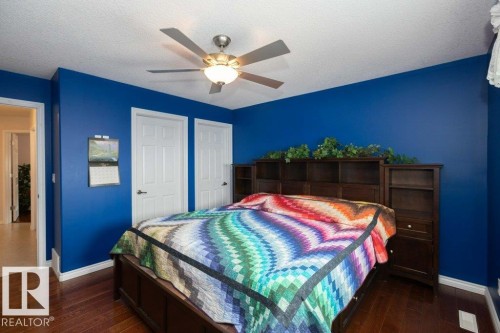 Bedroom featuring dark wood finished floors, a textured ceiling, a ceiling fan, and a closet - 11116 103 Street, Westlock, AB - Indoor Photo Showing Bedroom