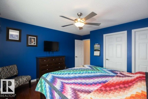 Bedroom featuring two closets, dark wood finished floors, a ceiling fan, and a textured ceiling - 11116 103 Street, Westlock, AB - Indoor Photo Showing Bedroom