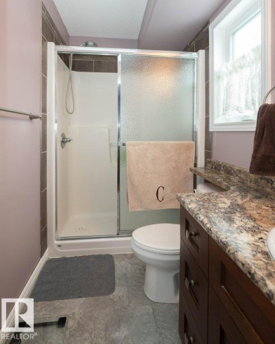 Full bath with a shower stall, vanity, and light tile patterned floors - 11116 103 Street, Westlock, AB - Indoor Photo Showing Bathroom