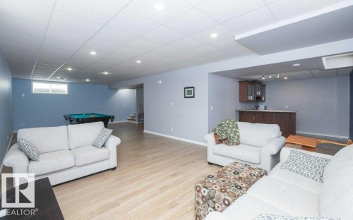 Living area with a paneled ceiling, billiards, light wood-style floors, recessed lighting, and wet bar - 11116 103 Street, Westlock, AB - Indoor