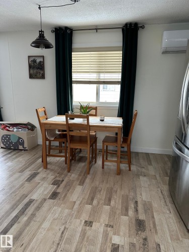 Dining room featuring a textured ceiling, light wood finished floors, and a wall mounted mini split - 341 West Brook Way Nw, Edmonton, AB - Indoor Photo Showing Dining Room