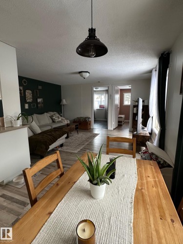 Dining area featuring wood finished floors and a textured ceiling - 341 West Brook Way Nw, Edmonton, AB - Indoor