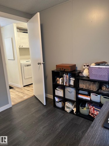 Office area with dark wood finished floors, washer / clothes dryer, and a textured ceiling - 341 West Brook Way Nw, Edmonton, AB - Indoor