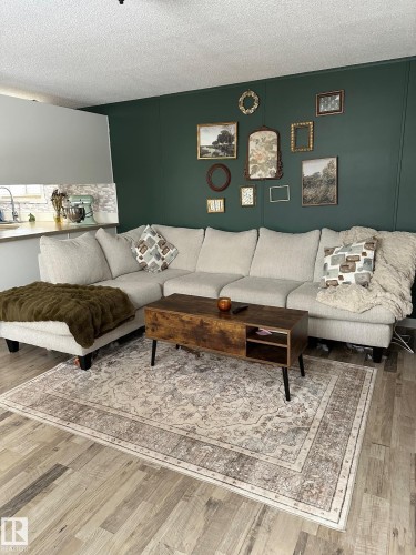 Living room featuring wood finished floors and a textured ceiling - 341 West Brook Way Nw, Edmonton, AB - Indoor Photo Showing Living Room