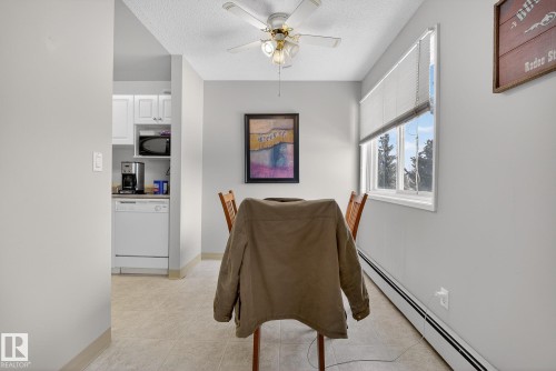 Dining room with baseboard heating, ceiling fan, light tile patterned flooring, and a textured ceiling - 302 4608 52 Avenue, Stony Plain, AB - Indoor Photo Showing Other Room