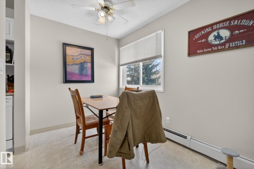 Dining room featuring a ceiling fan, a textured ceiling, a baseboard heating unit, and light tile patterned flooring - 302 4608 52 Avenue, Stony Plain, AB - Indoor Photo Showing Dining Room