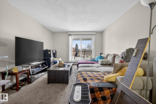 Carpeted living room with a textured ceiling - 307 4608 52 Avenue, Stony Plain, AB - Indoor Photo Showing Living Room