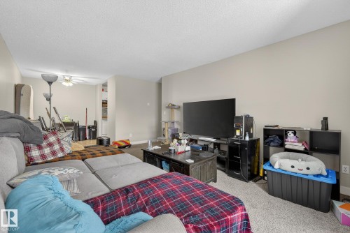 Bedroom featuring light carpet and a textured ceiling - 307 4608 52 Avenue, Stony Plain, AB - Indoor