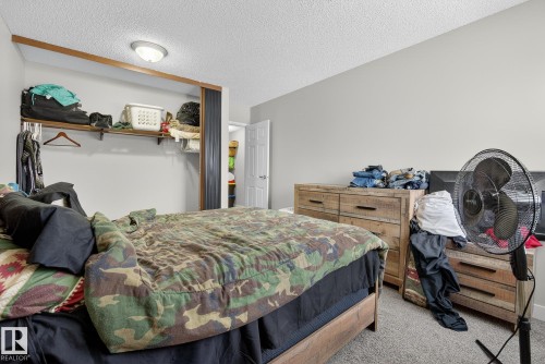 Carpeted bedroom featuring a textured ceiling - 307 4608 52 Avenue, Stony Plain, AB - Indoor Photo Showing Bedroom