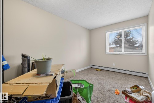 Office space featuring a baseboard radiator, light carpet, and a textured ceiling - 307 4608 52 Avenue, Stony Plain, AB - Indoor Photo Showing Office