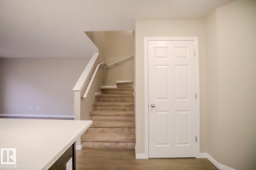 Stairs featuring wood finished floors and a textured ceiling - Edmonton, AB - Indoor Photo Showing Other Room