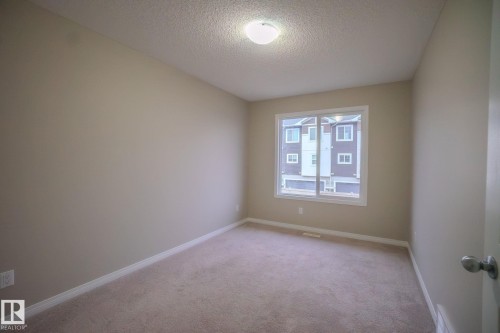 Empty room with a textured ceiling and light carpet - Edmonton, AB - Indoor Photo Showing Other Room