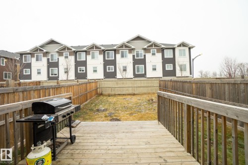 Wooden deck with a fenced backyard, area for grilling, and a residential view - Edmonton, AB - Outdoor