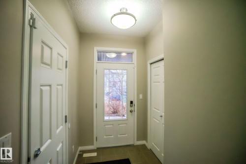Doorway with a textured ceiling and tile patterned flooring - Edmonton, AB - Indoor Photo Showing Other Room