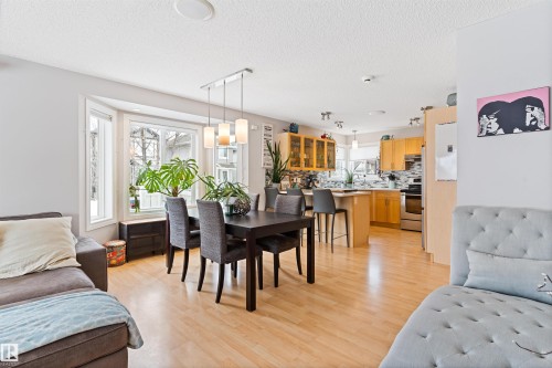 Dining room with rail lighting, light wood-style flooring, and a textured ceiling - 7804 Schmid Place, Edmonton, AB - Indoor