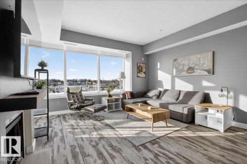 Living room featuring light wood-style floors, a fireplace, and a textured ceiling - 301 2504 109 Street, Edmonton, AB - Indoor Photo Showing Living Room