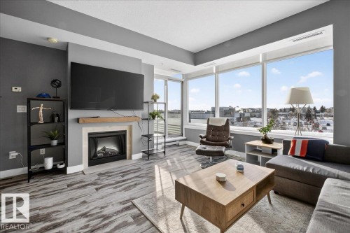 Living area with wood finished floors and a fireplace - 301 2504 109 Street, Edmonton, AB - Indoor Photo Showing Living Room With Fireplace