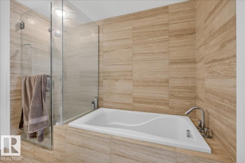 Full bath featuring a garden tub, a tile shower, and tile walls - 301 2504 109 Street, Edmonton, AB - Indoor Photo Showing Bathroom